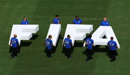 Pitch staff carry the Fifa logo on the pitch before the World Cup final